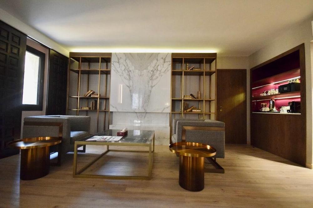 Makarem Ajyad Makkah Hotel Мека Екстериор снимка The photo shows a modern and stylish interior space, likely a living room or lounge area. On the left side, there are two comfortable gray armchairs positioned toward the center. A glass coffee table sits between them, featuring a few magazines or bo