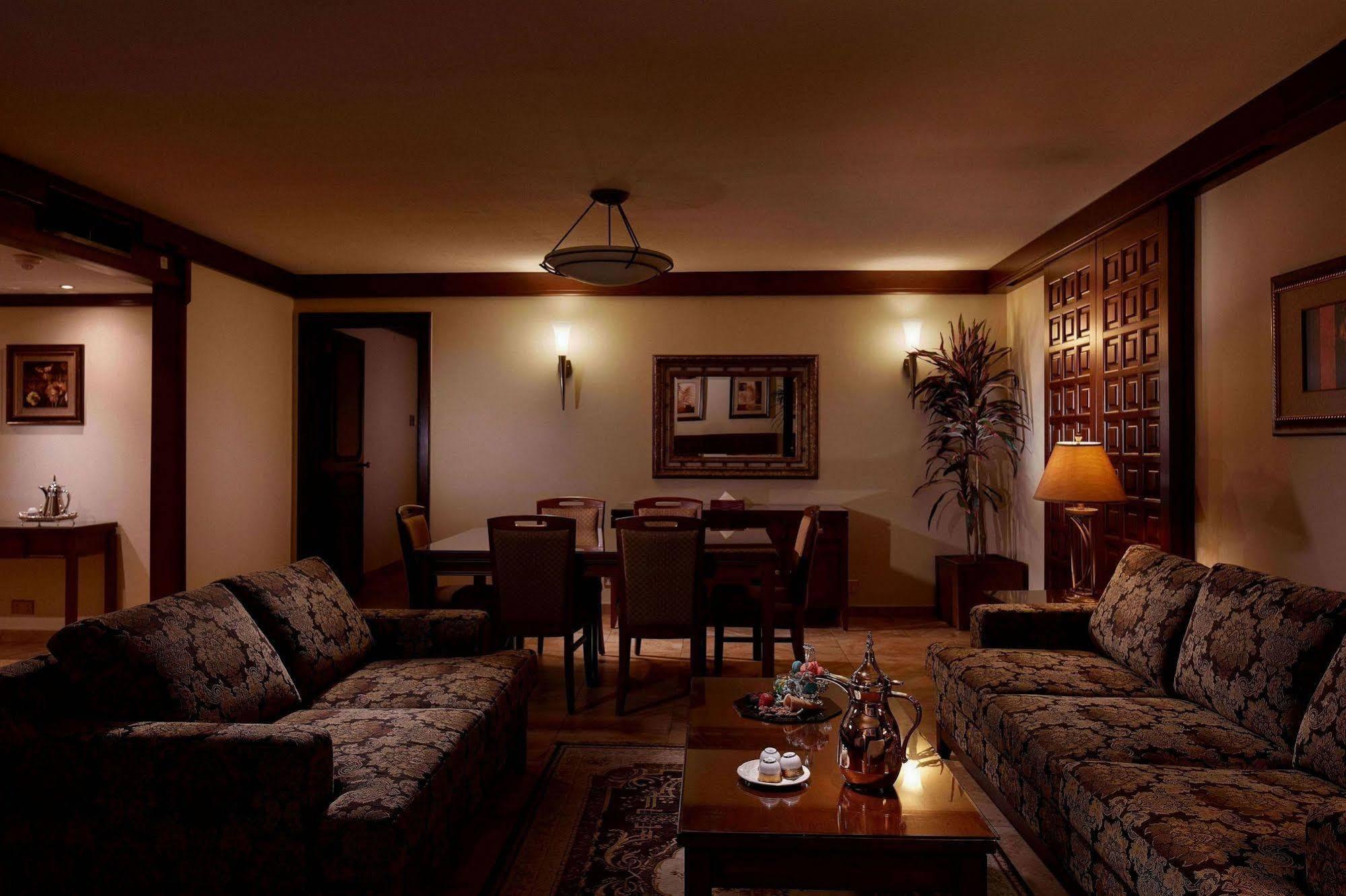 Makarem Ajyad Makkah Hotel Мека Екстериор снимка The photo depicts a cozy living room setting. It features two patterned sofas facing each other with a wooden coffee table in the center. The room is softly illuminated, creating a warm atmosphere. On the walls, there are decorative elements, includi