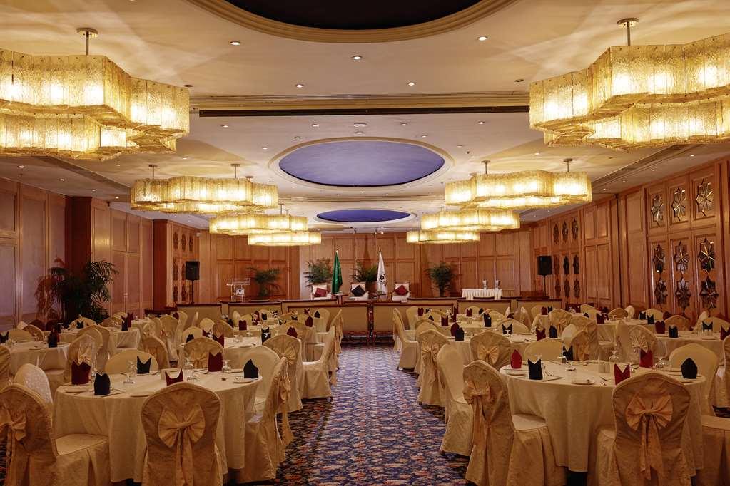 Makarem Ajyad Makkah Hotel Мека Съоръжения снимка The photo shows an elegantly arranged banquet or conference room. There are several round tables covered with light-colored tablecloths and adorned with decorative napkins. The seating is also stylish, with chairs featuring matching coverings. The ro