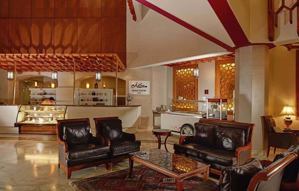 Makarem Ajyad Makkah Hotel Мека Интериор снимка The photo shows a stylish interior of a lobby or lounge area. It features a seating arrangement with dark leather armchairs and a wooden table in front of them. The decor includes an intricate ceiling design and decorative wall elements that add a wa