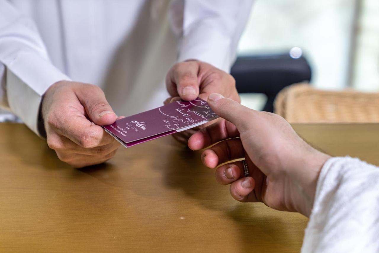 Makarem Ajyad Makkah Hotel Мека Екстериор снимка The photo shows two hands engaged in a transaction. One hand is extending a card towards another hand. The person handing over the card appears to be wearing a white garment, possibly a shirt or robe, while the person receiving the card has their han