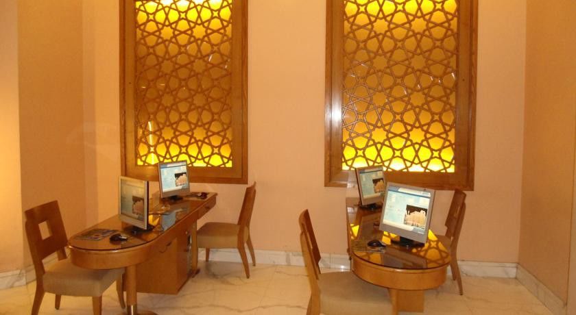 Makarem Ajyad Makkah Hotel Мека Екстериор снимка The image shows a room with a warm, inviting atmosphere, featuring two wooden desks equipped with computers. Each desk has a chair positioned in front of it. The walls are adorned with decorative panels that exhibit intricate patterns, illuminated by